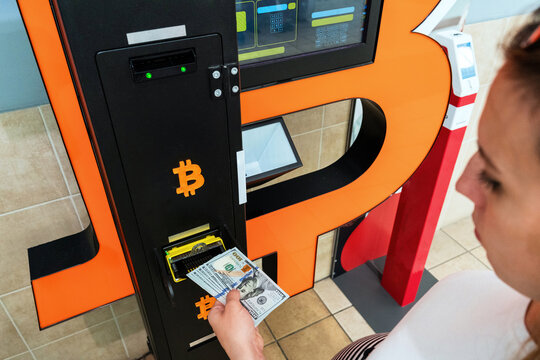 Atm cash bitcoin teller machine. Woman withdraw american dollar bill money. Usd hundred money payment on virtual crypto currency btc wallet. Bitcoin BTC ATM Cash Machine.