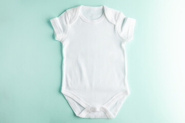 Mock-up of a white bodysuit for a baby made of natural cotton on a blue background for a boy. Close-up. Layout for the design and placement of logos, advertising.