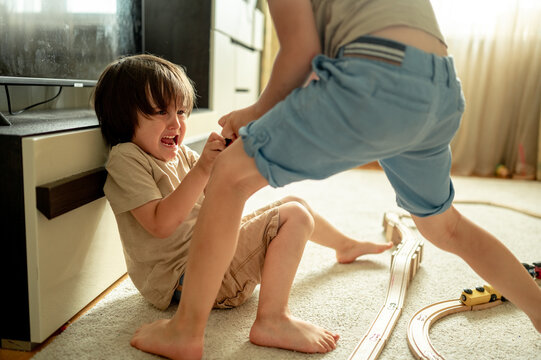 Two small children, brothers fighting over a toy. Conflict between children. Upset children