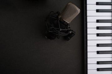 Studio microphone and midi keyboard on a gray background. Music, vocals, recording studio. There...
