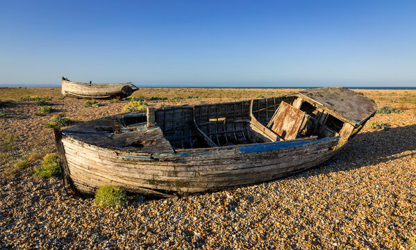Old wrecked fishing boats on the shingle of Dungeness beach on the Kent coast south east England