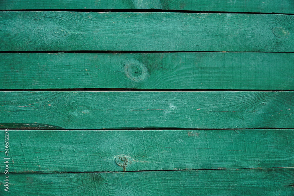 Wall mural Texture of an old fence made of wooden boards painted green color, close-up