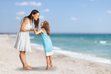 Happy mother with cute little girl on white tropical beach. Cheerful woman running along beach
