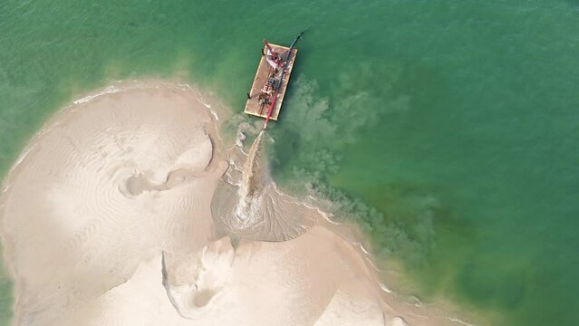 Panning and Tilting around a barge doing dredge work in summer.