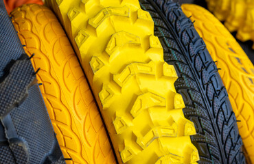 stack of tires for for agriculture machines,for sale.yellow,orange and black colors tires.outside...