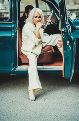 beautiful couple in retro style in suits stand near the car