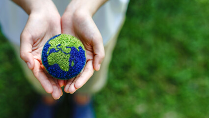 Hands holding the earth on a green background to protect nature Save and care World for...