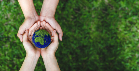 Many hands person holding the earth on a green background to protect nature Save and care World for sustainable. concept of the environment ecology and Earth Day - obrazy, fototapety, plakaty