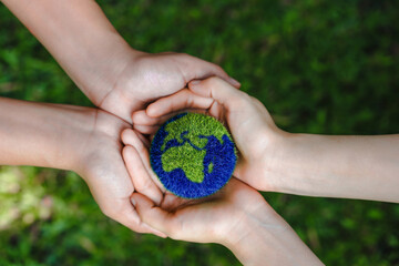 Many hands person holding the earth on a green background to protect nature Save and care World for sustainable. concept of the environment ecology and Earth Day