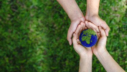 Many hands person holding the earth on a green background to protect nature Save and care World for...