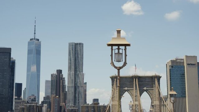 The One World Trade Center and the Brooklyn Bridge at a sunny day with a blue sky, static shot.