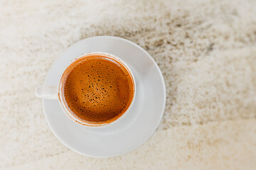 Strong coffee in a porcelain cup on the table in the cafe. An invigorating and flavorful decaf drink