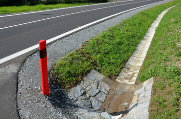Sewer pipes under the bridge. crossing ditch by side road. concrete hole with stone paving...