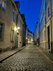 Fototapeta na wymiar One of the narrow, cobbled streets of Old Tallinn against the blue sky. Spring evening.