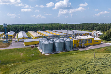 Fototapeta na wymiar aerial view on silos and agro-industrial livestock complex on agro-processing and manufacturing plant with modern granary elevator. chicken farm. rows of chicken coop