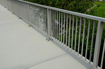railing at the bridge with vertical fence bars anchored to the ground with four concrete screws....