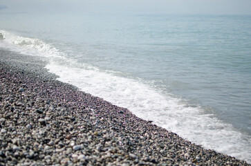 Sky, sea and sand with pebbles as a background. Natural landscape view of a beautiful tropical beach and sea on a sunny day. Beach sea area. Panorama of a beautiful beach with turquoise water banner.