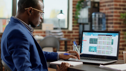 Fototapeta premium Financial analyst following real time stock market exchange on forex global trade report. Male broker analyzing currency statistics with profit to buy and sell hedge fund index money.
