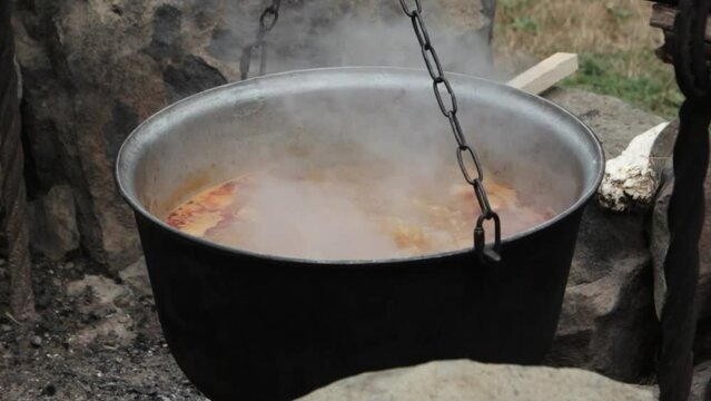 Traditional Hungarian bograch. Cooking on an open fire. Traditional Hungarian goulash in a cauldron. Transcarpathian dish. Soup with meat and chili pepper.