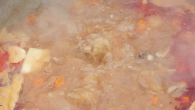 Traditional Hungarian bograch. Cooking on an open fire. Traditional Hungarian goulash in a cauldron. Transcarpathian dish. Soup with meat and chili pepper.