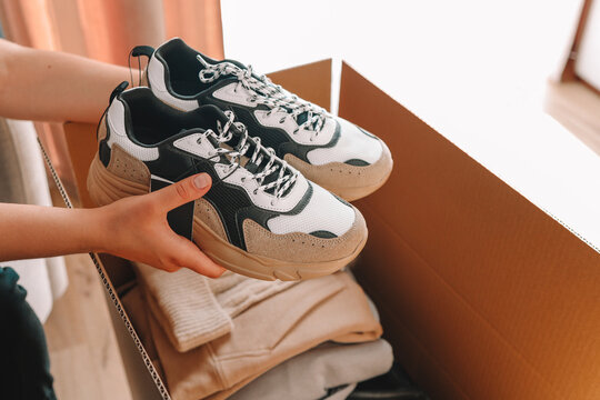 Men's sneakers and clothes in a box, shopping unpacking