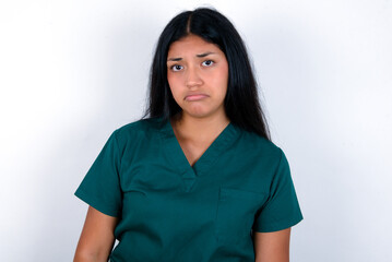 Doctor hispanic woman wearing surgeon uniform over white background depressed and worry for distress, crying angry and afraid. Sad expression.