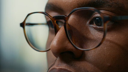 Closeup portrait of african american database developer with glasses working focused looking at...