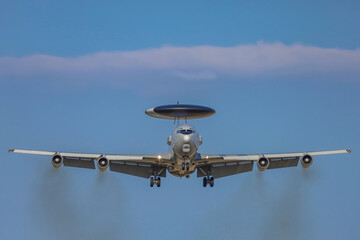 The plane against the blue sky. Landing plane front view