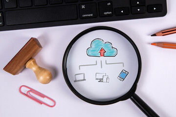 Cloud technology concept. Magnifying glass and computer keyboard on office table