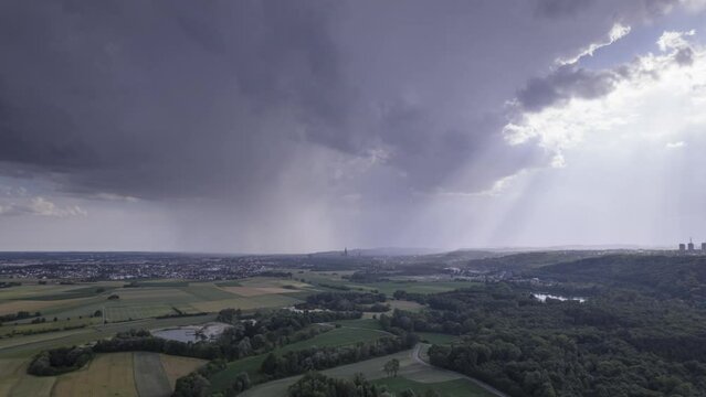 Rain clouds above Swabian landscape near Ulm with sun rays aerial time lapse