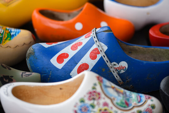 Koog aan de Zaan, Netherlands. July 2022. Colorful clogs against the background of a wooden wall. Popular souvenirs. Traditions of Holland.