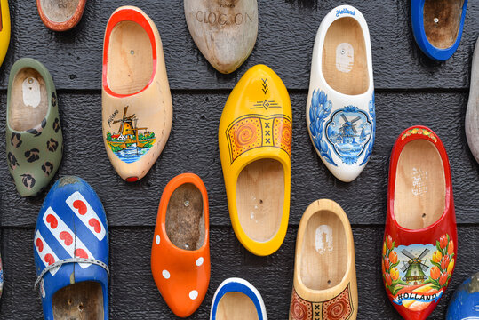 Koog aan de Zaan, Netherlands. July 2022. Colorful clogs against the background of a wooden wall. Popular souvenirs. Traditions of Holland.
