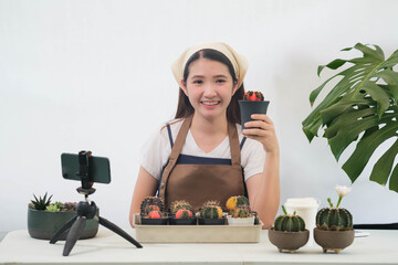 Beautiful Asian girls selling cactus plants online.Yong florist using interface of online flower...