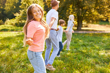 Girl holding hands with family while running