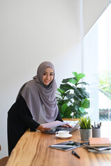 Muslim business woman working with charts, statistics and data at bright modern office