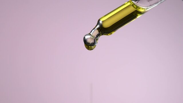 Drop of serum with glass cosmetic dropper on pink background. Close-up video.