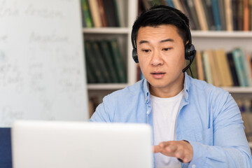 Asian Man Making Video Call Talking To Laptop At Workplace