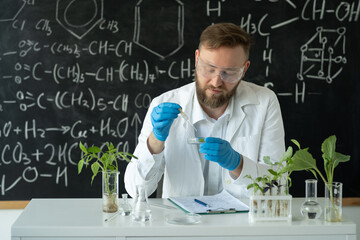 A biotechnologist in a modern laboratory conducts experiments with synthesizing compounds using...