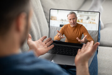 Distant Communication. Young Male With Laptop Making Video Call To Senior Man