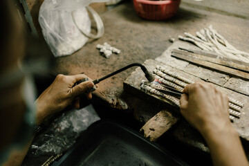 Jeweler at work in jewelry. Desktop for craft jewelry making with professional tools. Close up view of tools. Silver jewelry. Unique local artwork in Nan Province northern thailand