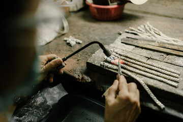 Jeweler at work in jewelry. Desktop for craft jewelry making with professional tools. Close up view of tools. Silver jewelry. Unique local artwork in Nan Province northern thailand