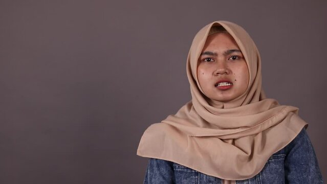 Asian hijab woman get pissed and angry isolated grey background