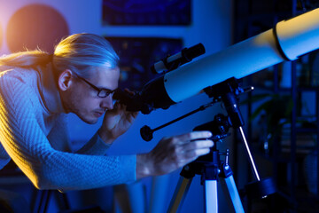 Astronomer man looks through telescope at the night sky, space, cosmos, universe, Milky way. Male...
