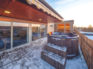 Open terrace with hot outdoor wooden bath tub. Luxury private house.