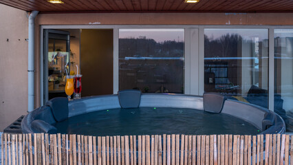 Open terrace with hot outdoor wooden bath tub. Luxury private house.