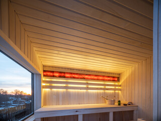 Interior of wooden finnish sauna with window. Luxury private house.