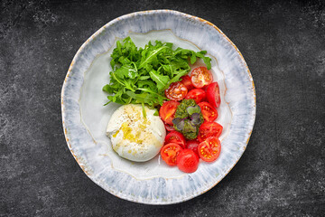 Burrata with arugula, cherry tomatoes and pesto sauce