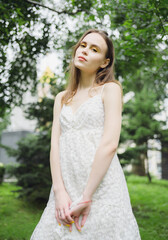 City portrait of beautiful young woman in white dress.