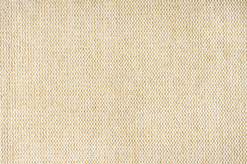 Close-up texture of natural beige coarse weave fabric or cloth. Fabric texture of natural cotton or linen textile material. Blue canvas background. Decorative fabric for upholstery, furniture, walls