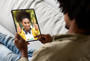 Young Black Man Using Digital Tablet For Video Call At Home